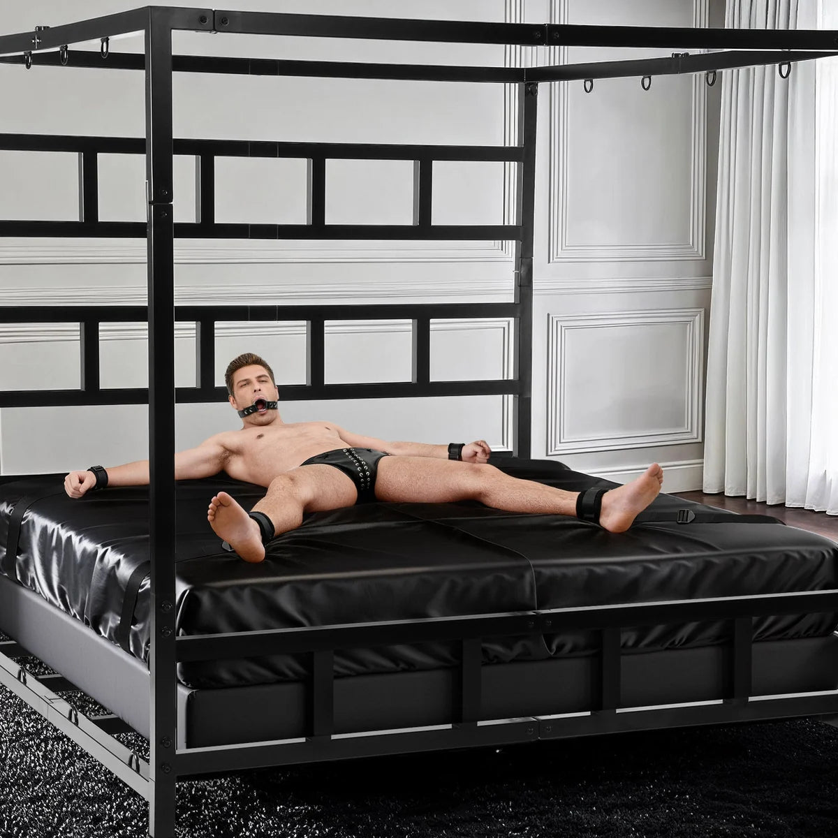 Gagged model cuffed spread-eagle to the D-rings of the King Size Bondage Bed, Fort Troff