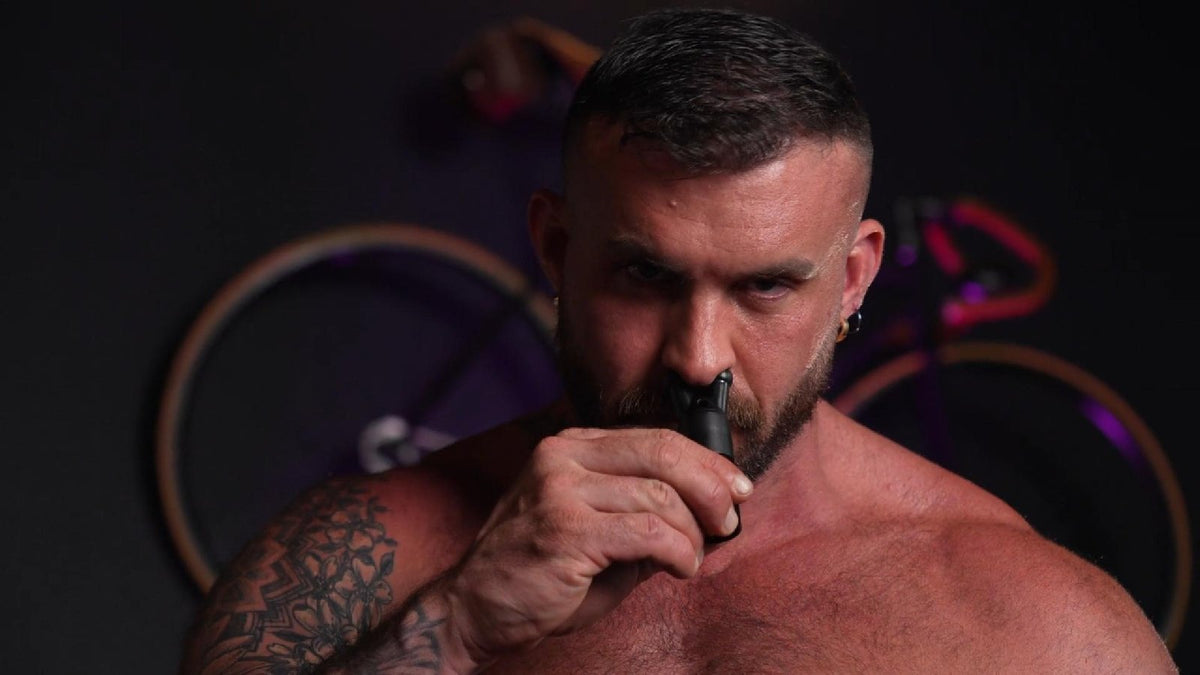 Bearded model using the Pig Snout X incense inhaler in low neon light