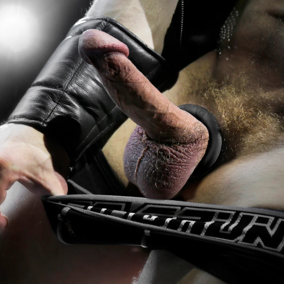 Cush Ring soft silicone cock ring worn under a leather jockstrap, close-up, Fort Troff