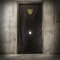 Doorway Glory Hole Kit black nylon curtain hung in a concrete doorway with tension bar, Fort Troff