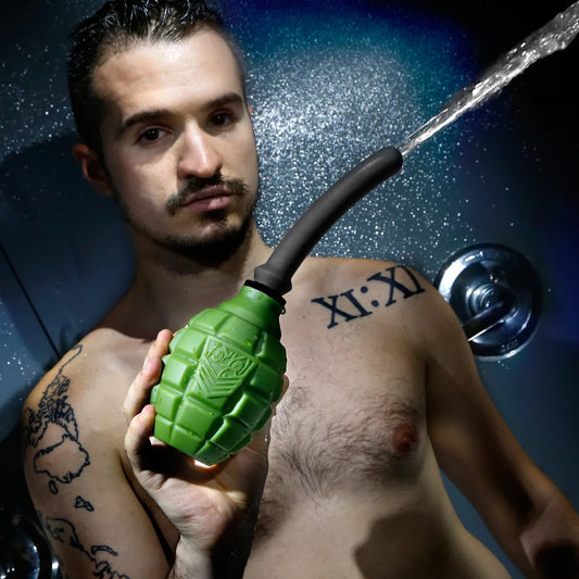 Grenade anal douche bulb spraying water, held by a model in the shower, Fort Troff
