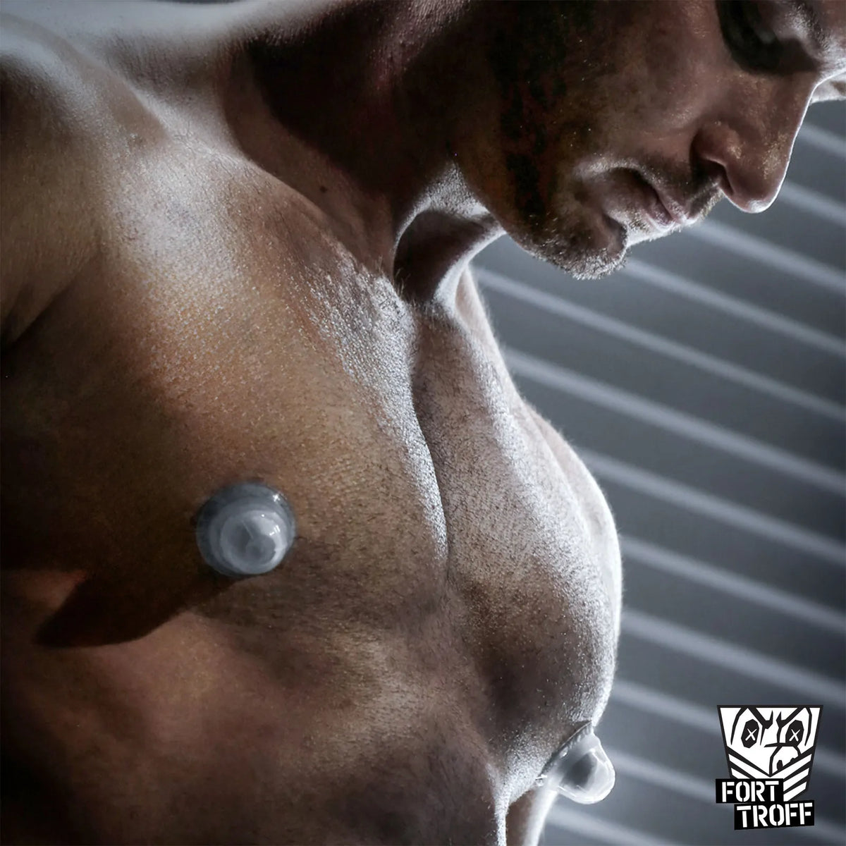 Silicone Nip Sucker Large clear cups suctioned to a muscular model's chest, Fort Troff