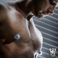 Silicone Nip Sucker Large clear cups suctioned to a muscular model's chest, Fort Troff
