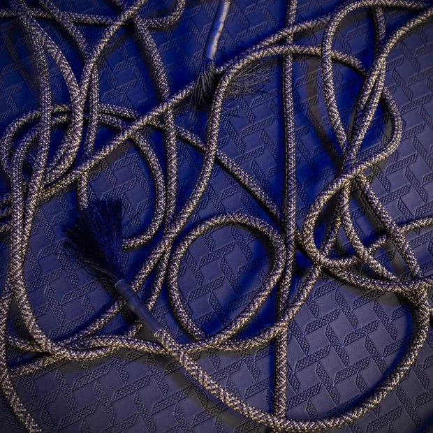 Grunt Rope bondage rope loosely looped on the floor with frayed tassel end, Fort Troff