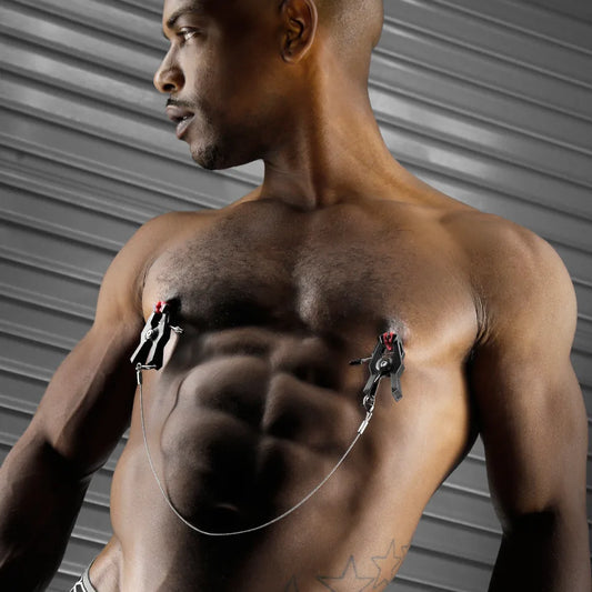 MegaGrip Jumper Nipple Clamps with steel chain worn on a muscular chest, Fort Troff