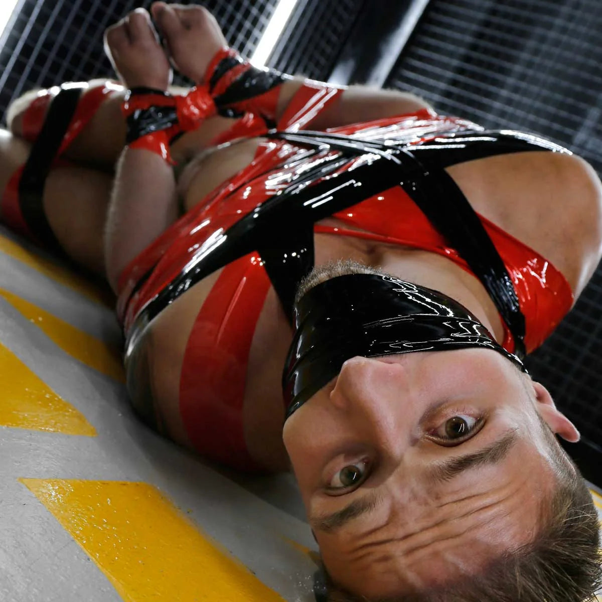 Mega-Roll red bondage tape wrapped around a model's chest and eyes, upside-down view, Fort Troff
