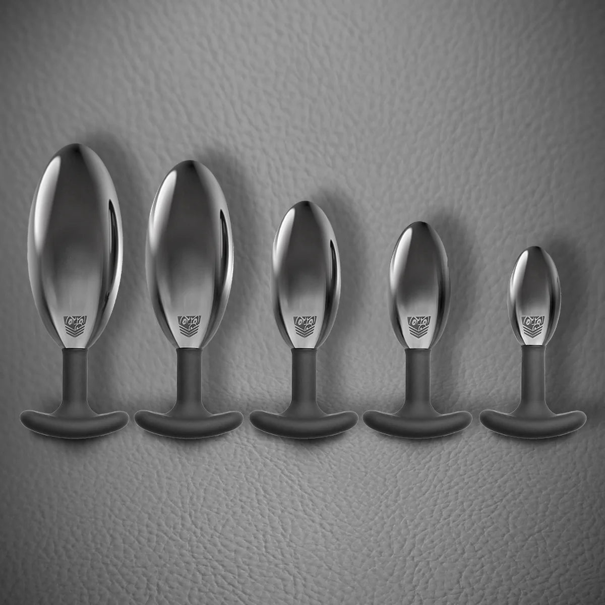 Spring Loaded metal butt plug full size range lined up from XXL to small, Fort Troff