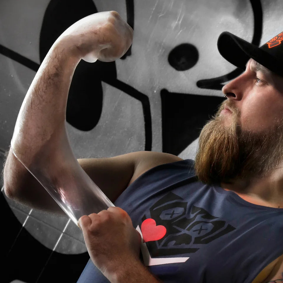 Bearded model in a cap flexing an arm in the FFister XL Peek-A-Boo Clear glove, Fort Troff