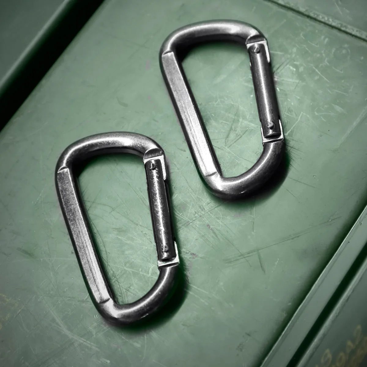 2 steel carabiner clips for bondage restraints on an olive ammo box, Fort Troff