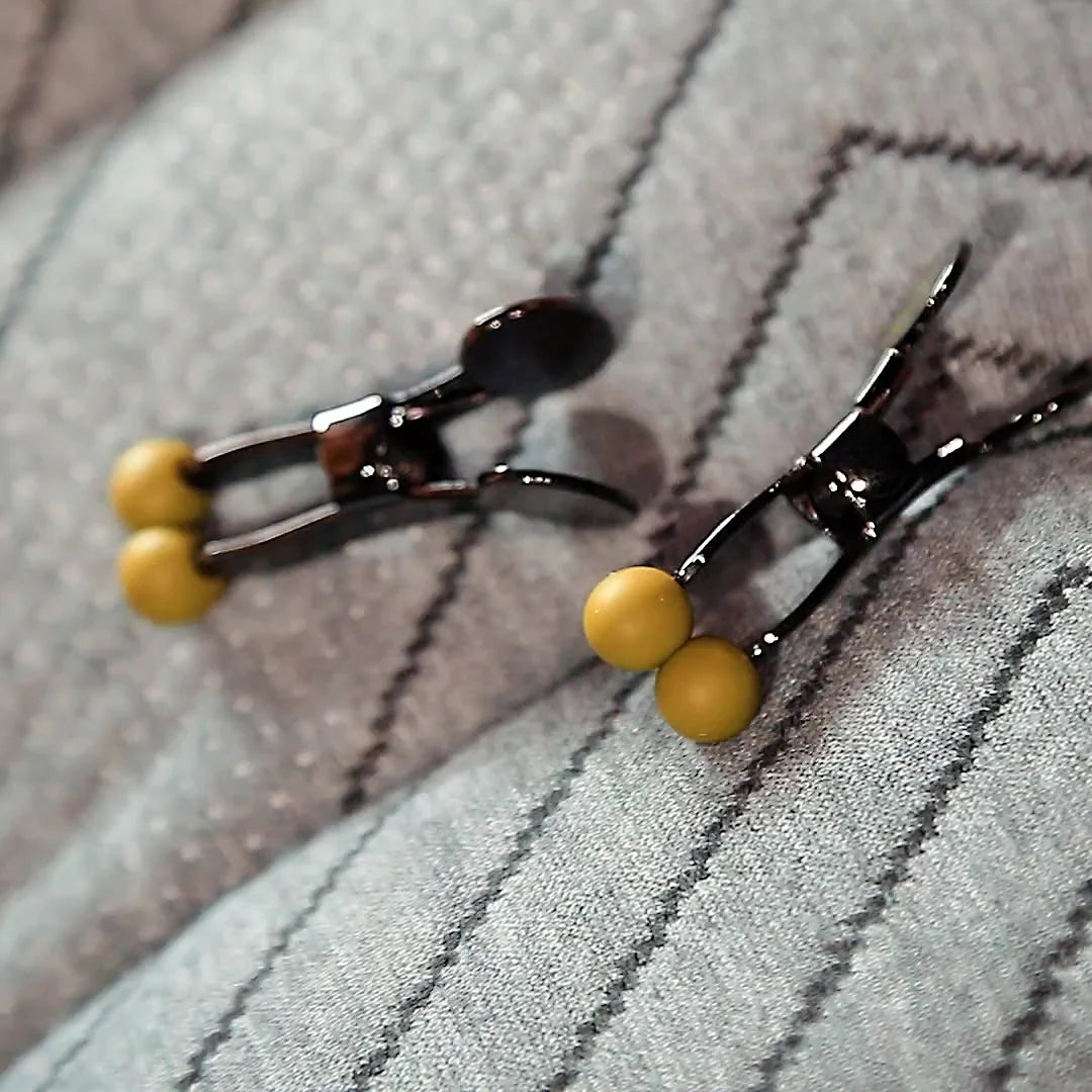 Pair of Captive Grip stainless steel nipple clamps with round yellow silicone tips, Fort Troff