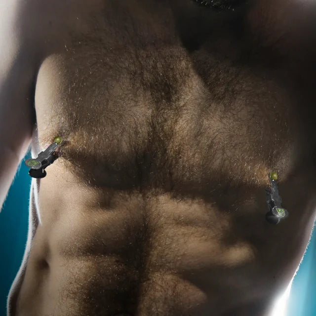 Captive Grip stainless steel nipple clamps on both nipples of a hairy, bearded model, Fort Troff